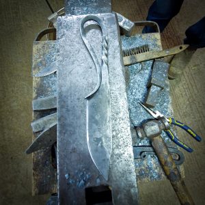 Finished Viking knife resting on an anvil